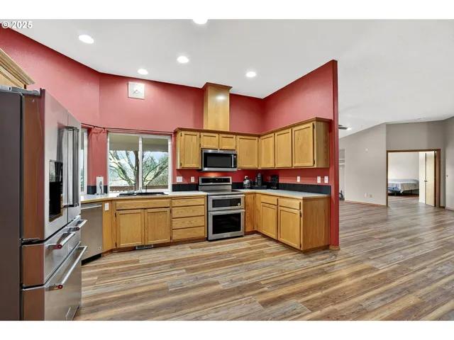 a kitchen with stainless steel appliances kitchen island granite countertop a stove and a refrigerator