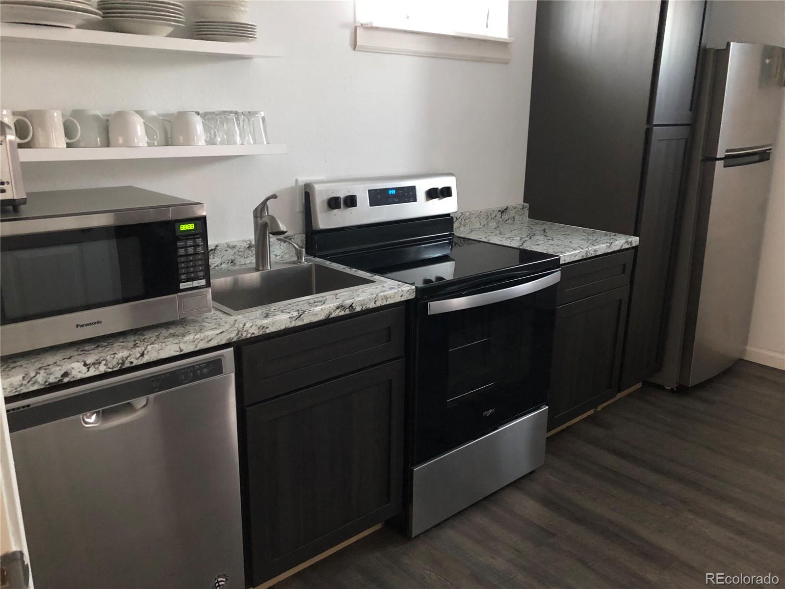 1671 North State Highway 83, Unit B Franktown, CO 80116 - Photo 11 of 21 a kitchen with granite countertop a stove and a microwave