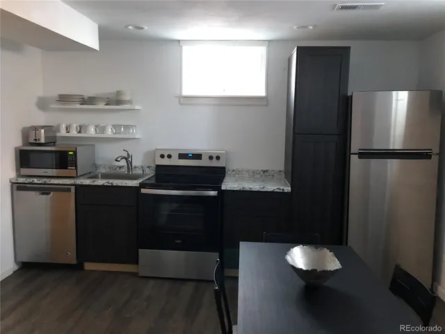a kitchen with a refrigerator and a stove top oven