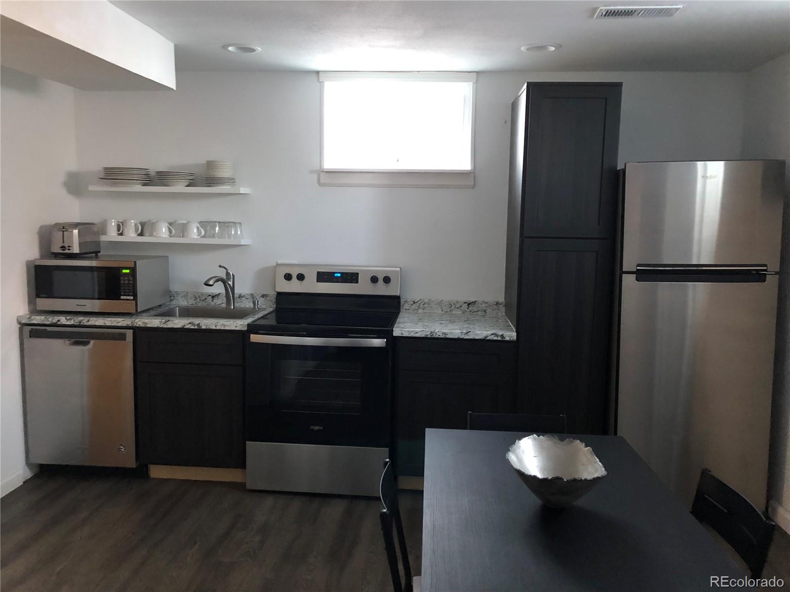 1671 North State Highway 83, Unit B Franktown, CO 80116 - Photo 9 of 21 a kitchen with a refrigerator and a stove top oven