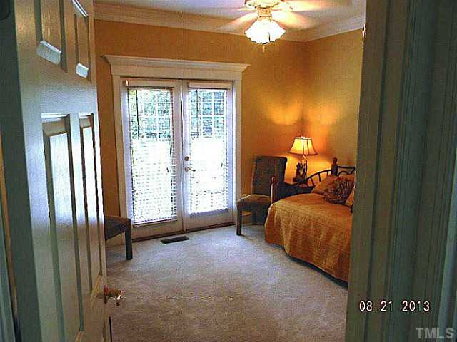 5205 Deergrass Court Raleigh, NC 27613 - Photo 16 of 25 First floor bedroom has its own bathroom and French doors leading to the lush backyard and pool area. Bedroom