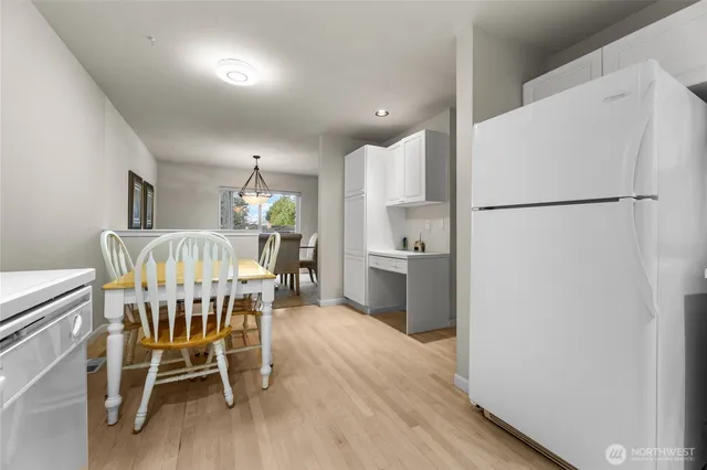 a kitchen with a table chairs refrigerator and microwave