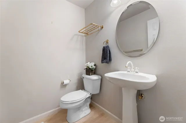 a bathroom with a toilet a sink and mirror