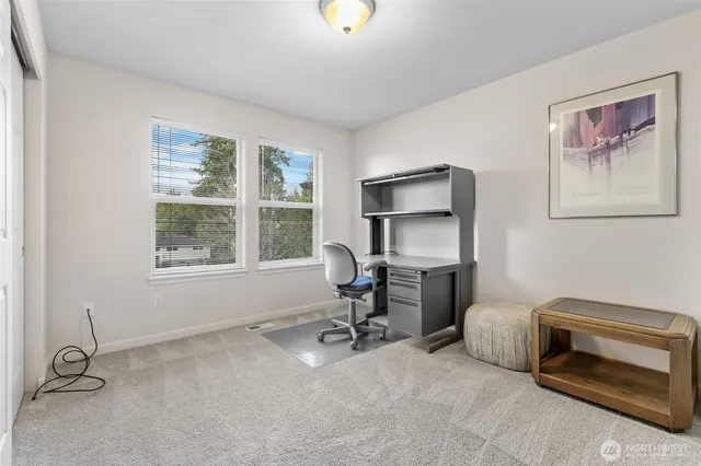 a view of a workspace with furniture and a window