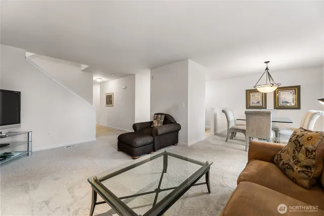 a living room with furniture a flat screen tv and a window