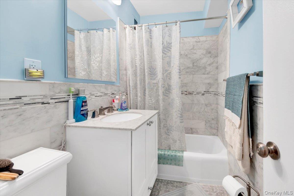 3777 Independence Avenue, Unit 16F Bronx, NY 10463 - Photo 12 of 27 a bathroom with a sink a bath tub and a shower curtain