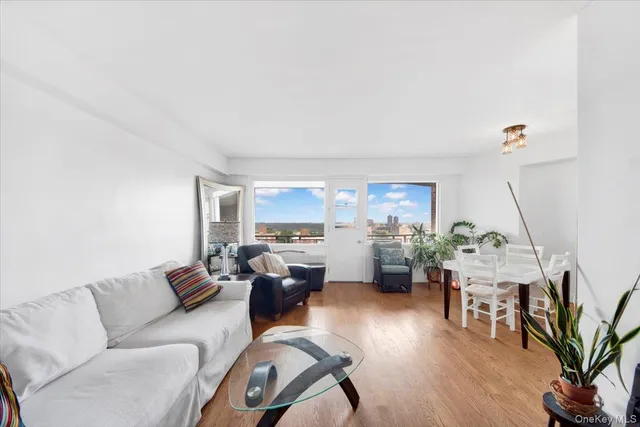 a living room with furniture a flat screen tv and a wooden floor