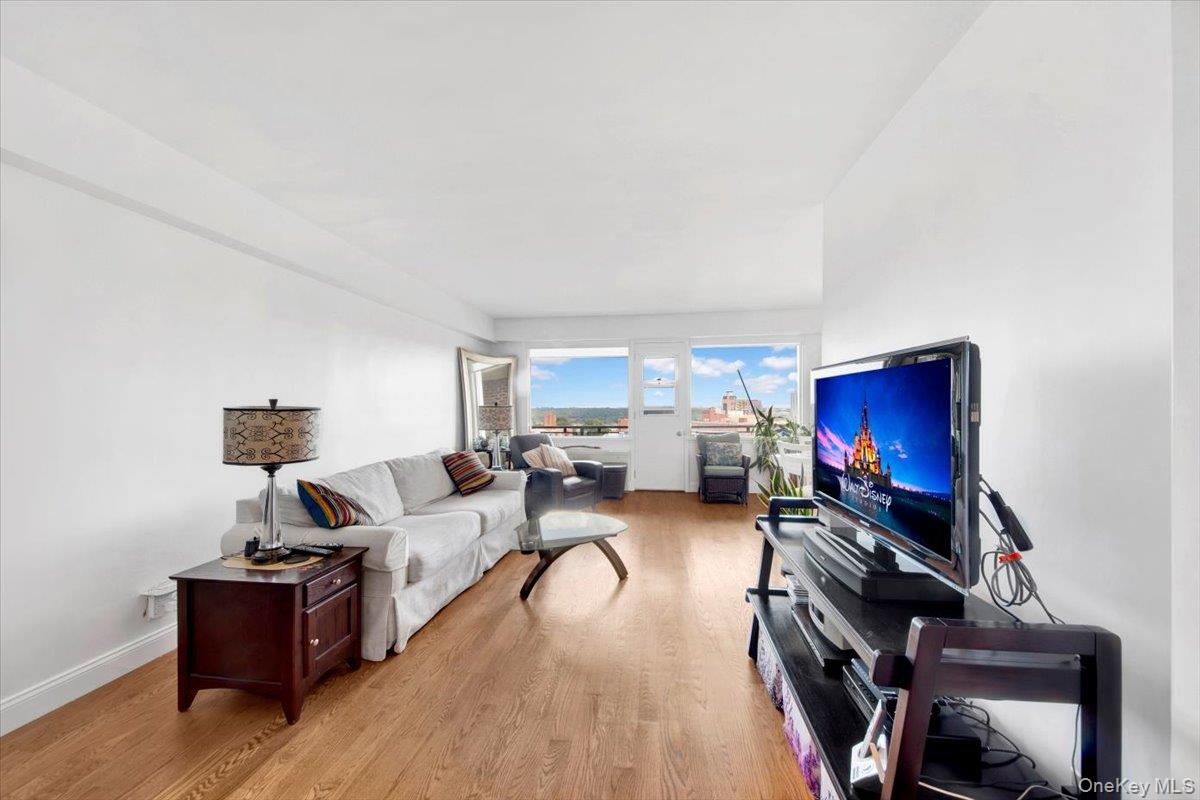 3777 Independence Avenue, Unit 16F Bronx, NY 10463 - Photo 17 of 27 a living room with furniture a flat screen tv and a wooden floor