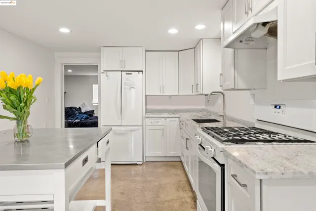 a kitchen with white cabinets and appliances