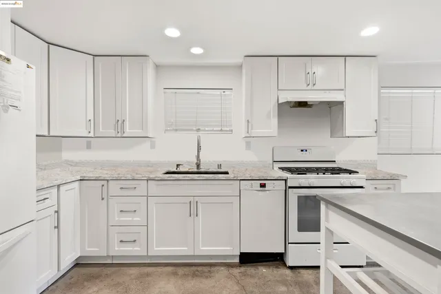 a kitchen with white cabinets and white appliances