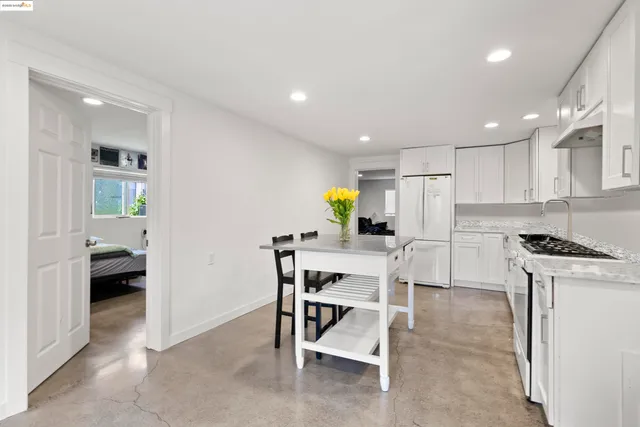 a kitchen with a sink a refrigerator and chairs