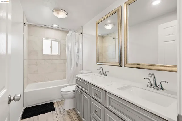 a bathroom with a granite countertop sink a toilet and a large mirror