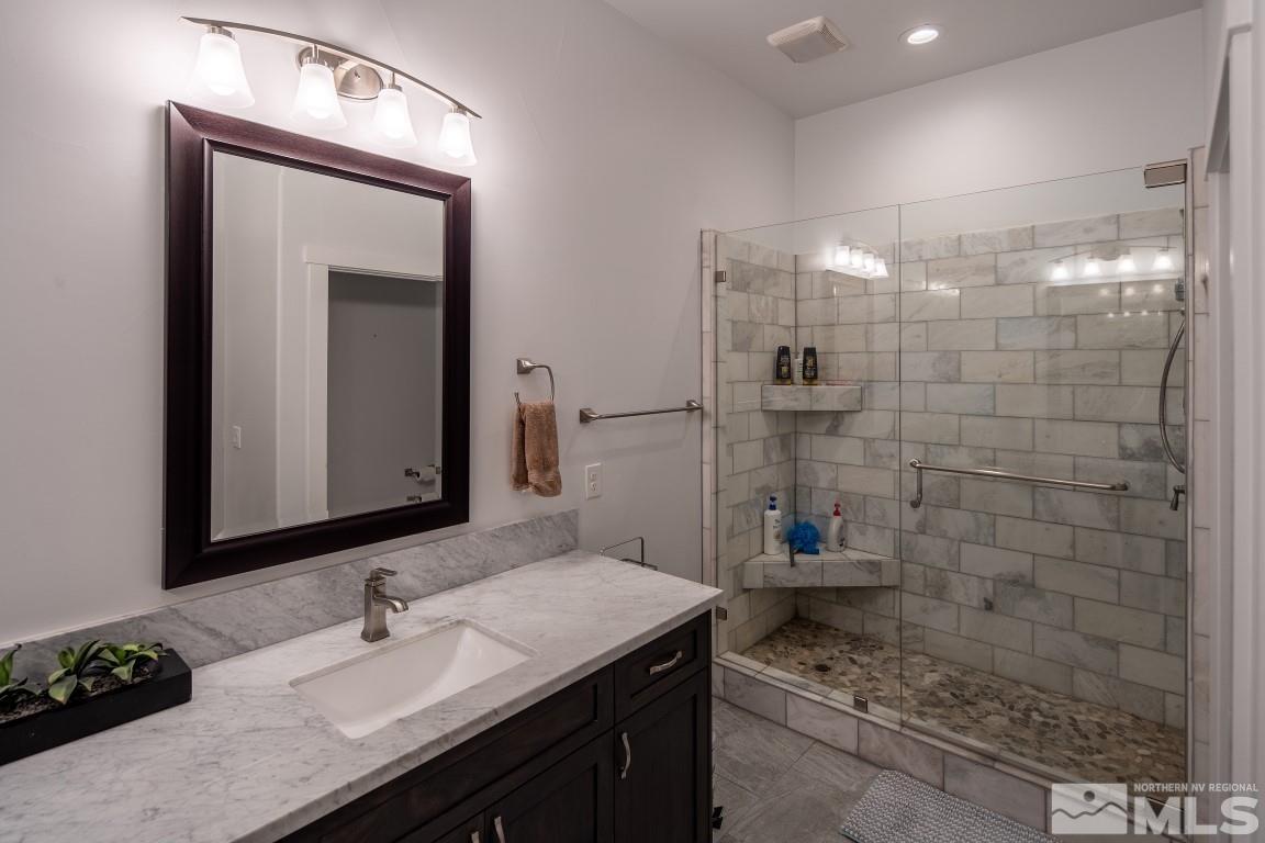 4610 Tybo Road Reno, NV 89521 - Photo 32 of 40 a bathroom with a granite countertop sink a toilet and shower