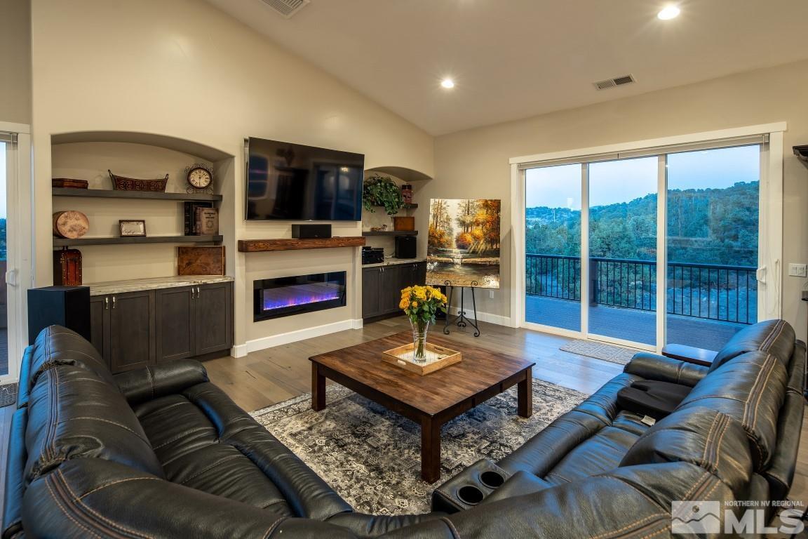4610 Tybo Road Reno, NV 89521 - Photo 8 of 40 a living room with furniture a flat screen tv and a floor to ceiling window