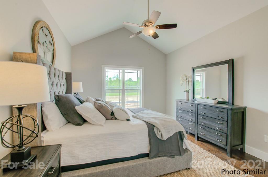 235 Hayes Rdg Lane, Unit 14 Mills River, NC 28759 - Photo 11 of 18 a bedroom with a bed dresser and wooden floor