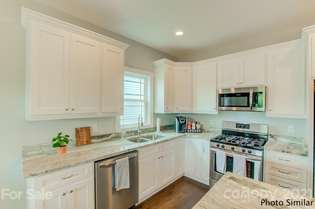 235 Hayes Rdg Lane, Unit 14 Mills River, NC 28759 - Photo 6 of 18 a kitchen with stainless steel appliances granite countertop a stove a sink and a white cabinets
