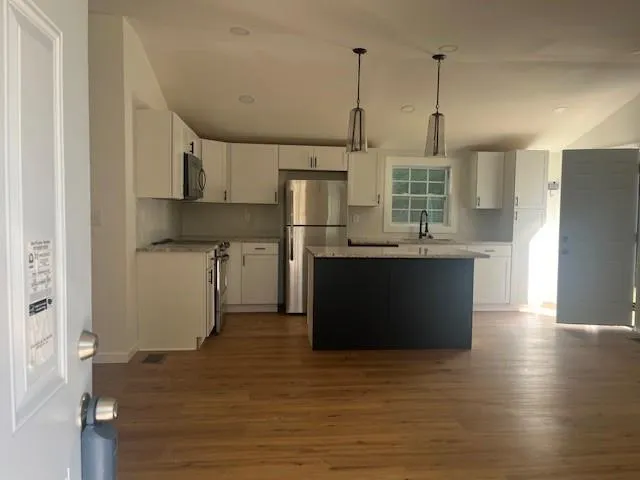 a kitchen with stainless steel appliances granite countertop a sink a stove and a refrigerator