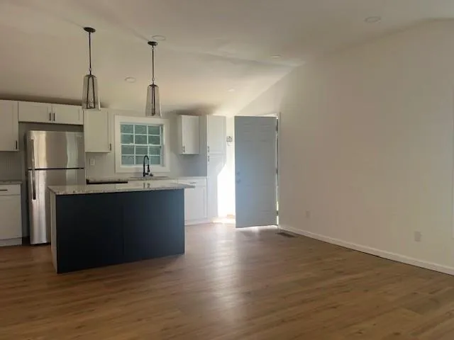 a kitchen with stainless steel appliances a refrigerator and wooden floor