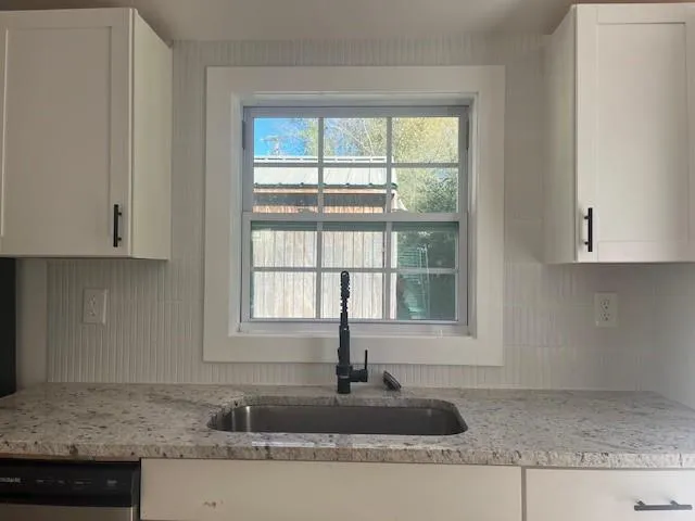 a kitchen with granite countertop a sink and a window