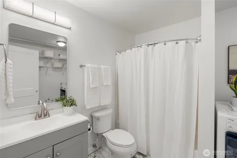 a bathroom with a sink a toilet a mirror and shower curtain