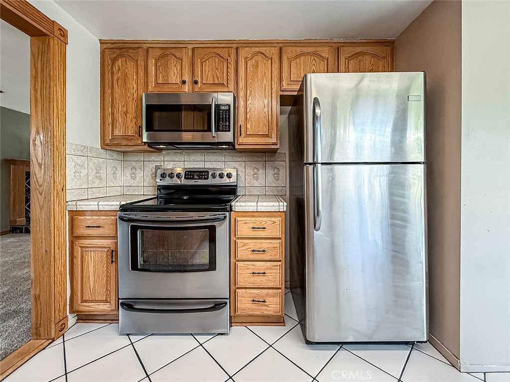 2235 Burnside Street Simi Valley, CA 93065 - Photo 28 of 71 a kitchen with stainless steel appliances granite countertop a refrigerator stove and microwave