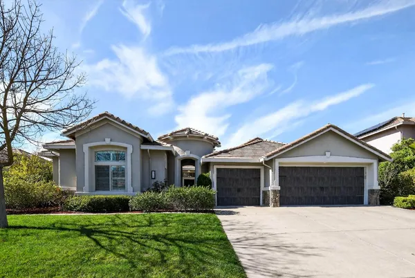 a front view of a house with a garden and yard
