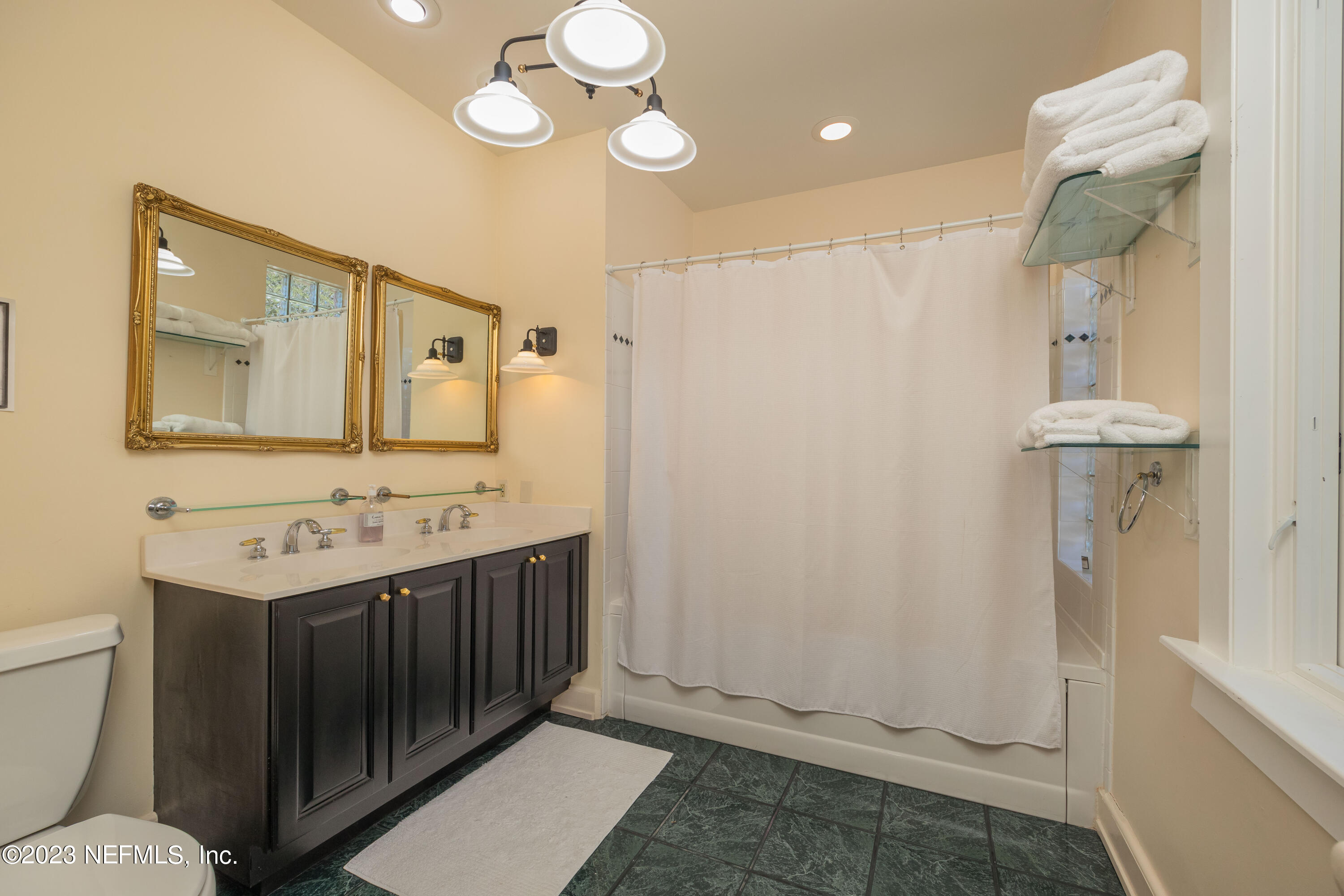 16 May Street St. Augustine, FL 32084 - Photo 60 of 86 a bathroom with a sink a toilet and mirror