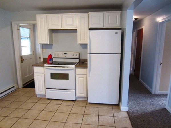 a kitchen with a stove top oven and refrigerator