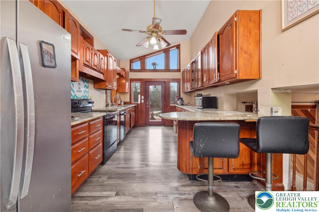 120 Royal Manor Road Easton, PA 18042 - Photo 9 of 49 a kitchen with stainless steel appliances granite countertop a refrigerator a stove top oven a dining table and chairs with wooden floor
