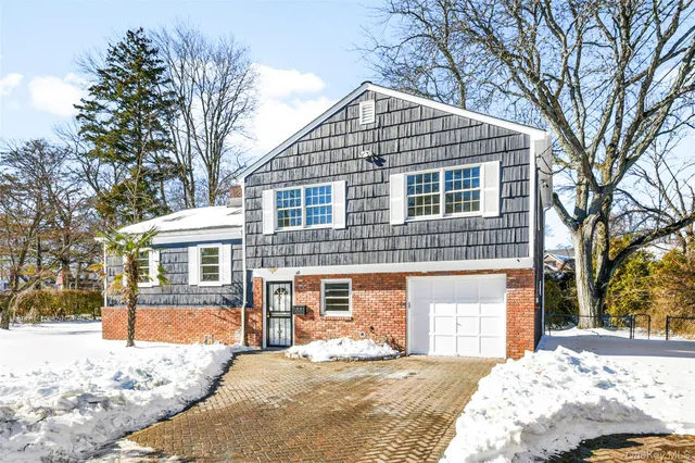 a front view of a house with a yard covered in snow