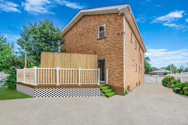 a view of a brick house with a large trees