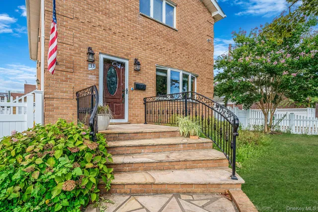a view of a house with a small yard plants and large tree