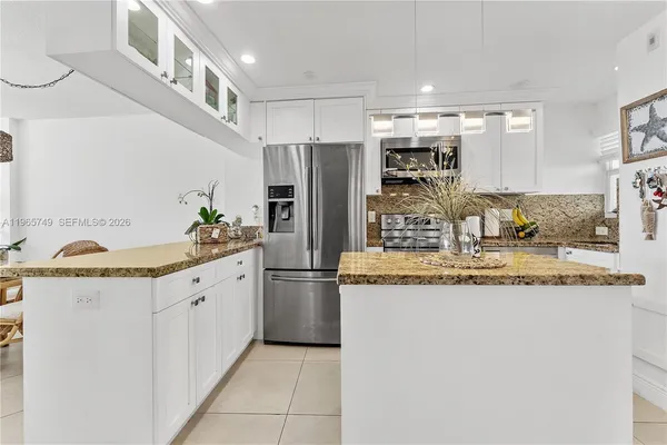 a kitchen with granite countertop a sink and refrigerator