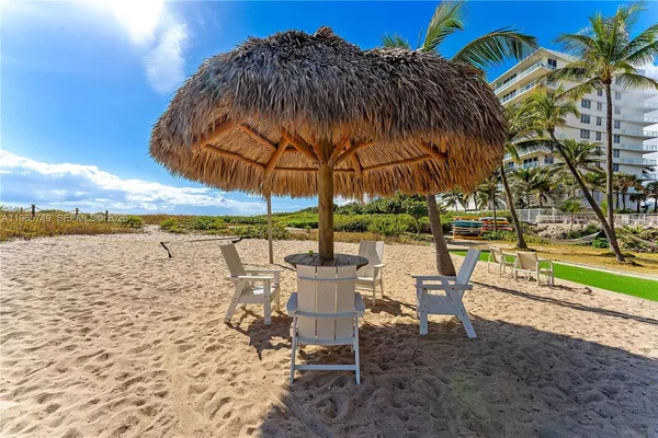 a view of a lake with table and chairs under an umbrella