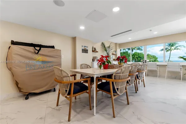 a dining room with furniture and a floor to ceiling window