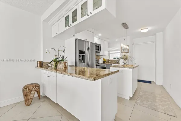 a kitchen with stainless steel appliances kitchen island granite countertop a sink and cabinets