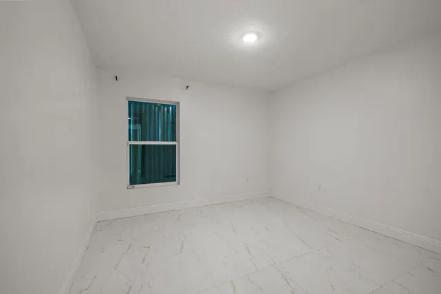 an empty room with a window and closet