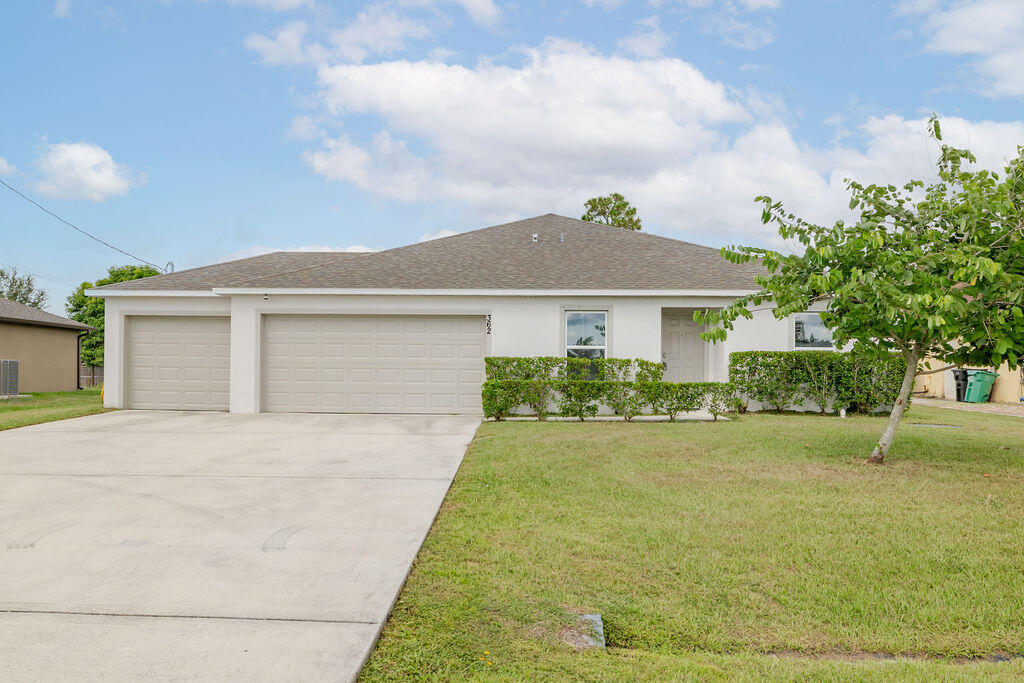 362 Northwest Bayshore Boulevard Port St. Lucie, FL 34983 - Photo 24 of 32 a front view of a house with a yard and garage