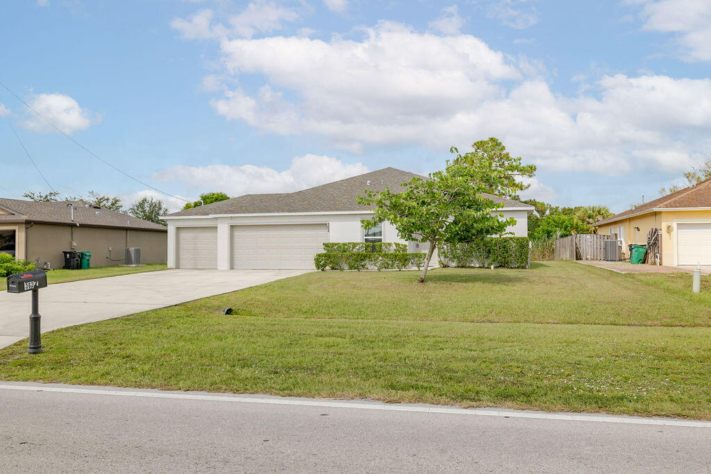 362 Northwest Bayshore Boulevard Port St. Lucie, FL 34983 - Photo 29 of 32 a front view of a house with a garden and yard