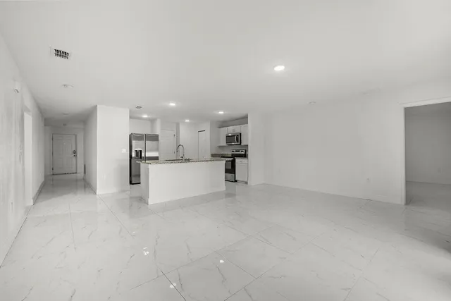 a view of a kitchen with a sink and a refrigerator