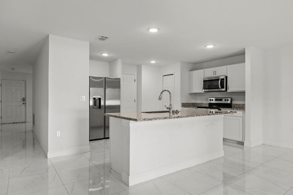 362 Northwest Bayshore Boulevard Port St. Lucie, FL 34983 - Photo 7 of 32 a kitchen with stainless steel appliances granite countertop a refrigerator and a stove