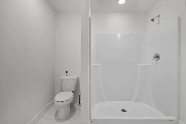 a bathroom with a toilet and a shower