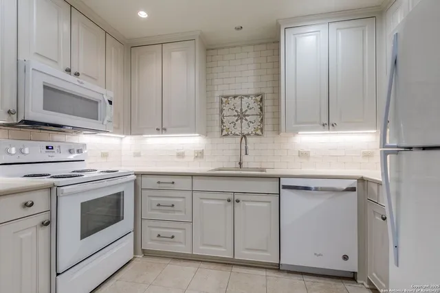 a kitchen with cabinets appliances a sink and a counter top