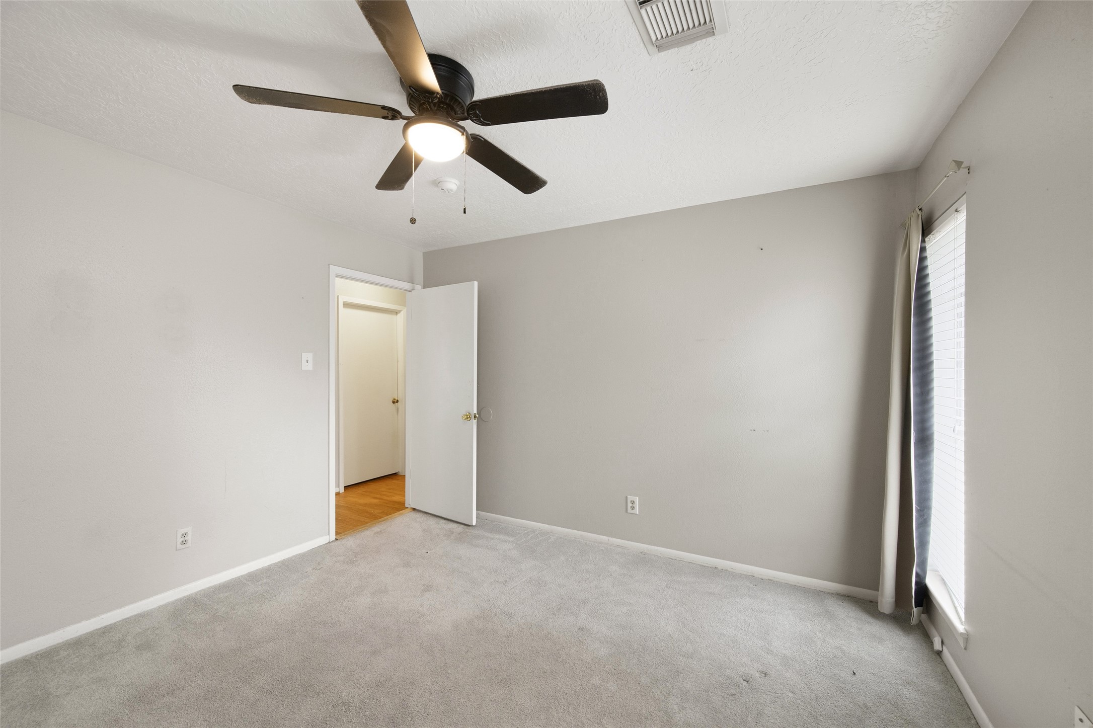 4205 Lariat Drive Baytown, TX 77521 - Photo 25 of 31 an empty room with a ceiling fan and carpet
