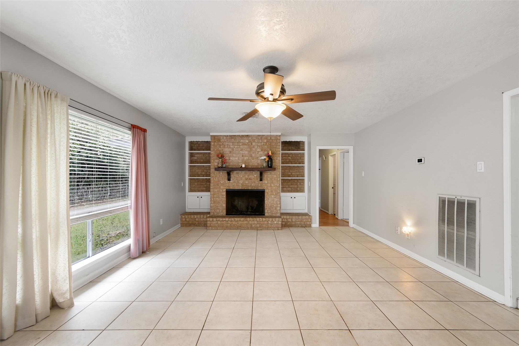 4205 Lariat Drive Baytown, TX 77521 - Photo 6 of 31 a view of an empty room with a fireplace and a window