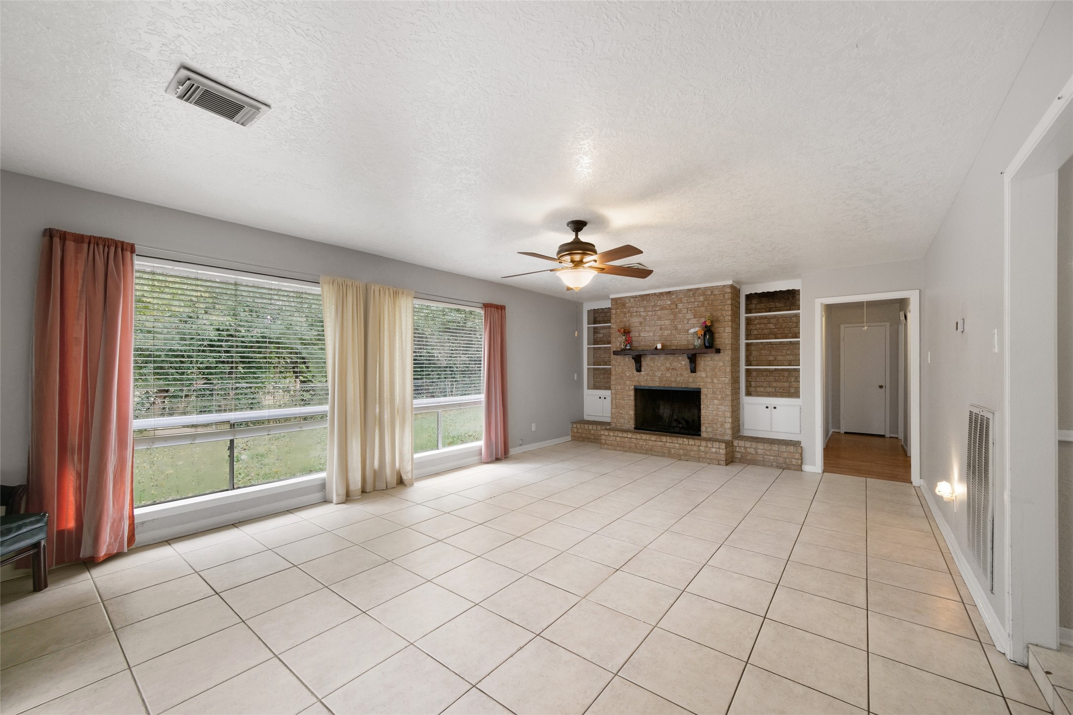 4205 Lariat Drive Baytown, TX 77521 - Photo 7 of 31 an empty room with fireplace and windows