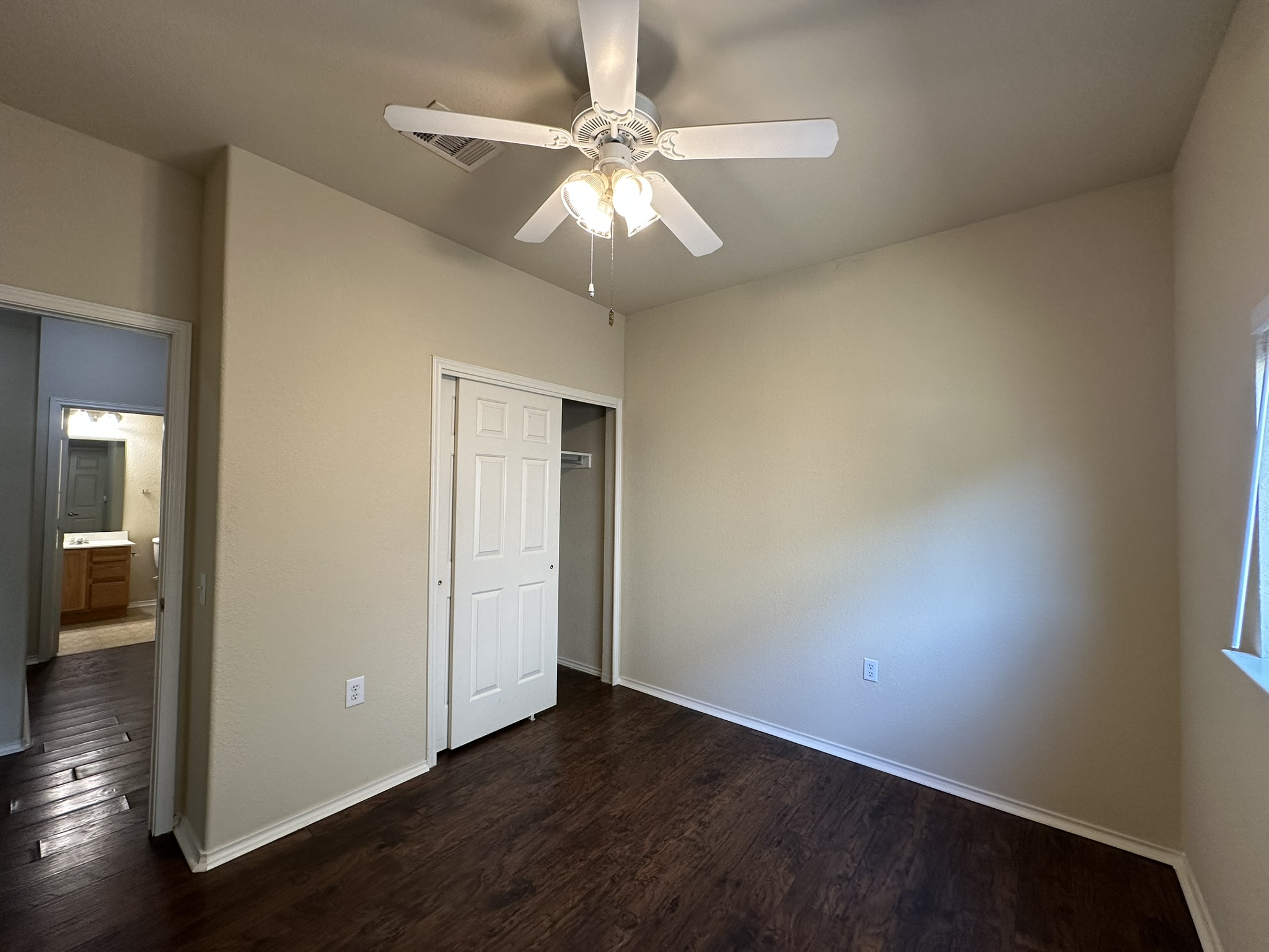 4507 Peach Grove Road Austin, TX 78744 - Photo 26 of 35 Rich dark wood floors and crisp baseboards ground this inviting secondary space.