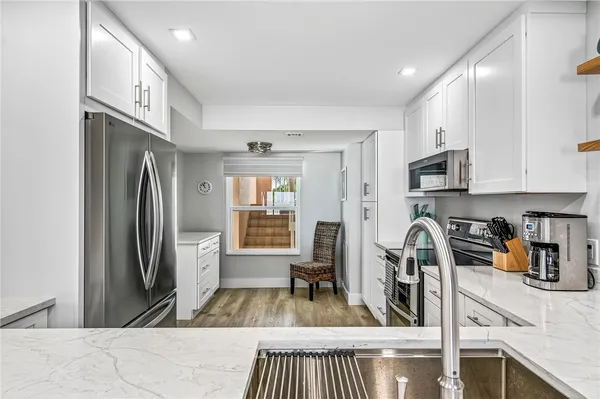 a kitchen with stainless steel appliances granite countertop a refrigerator and a stove top oven