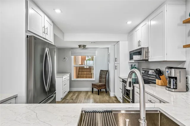 a kitchen with stainless steel appliances granite countertop a refrigerator and a stove top oven