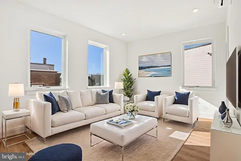 a living room with furniture a rug a table and a window